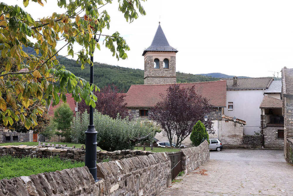 Calle de Aragüés del Puerto, tras un tejado se ve la torre de la iglesia
