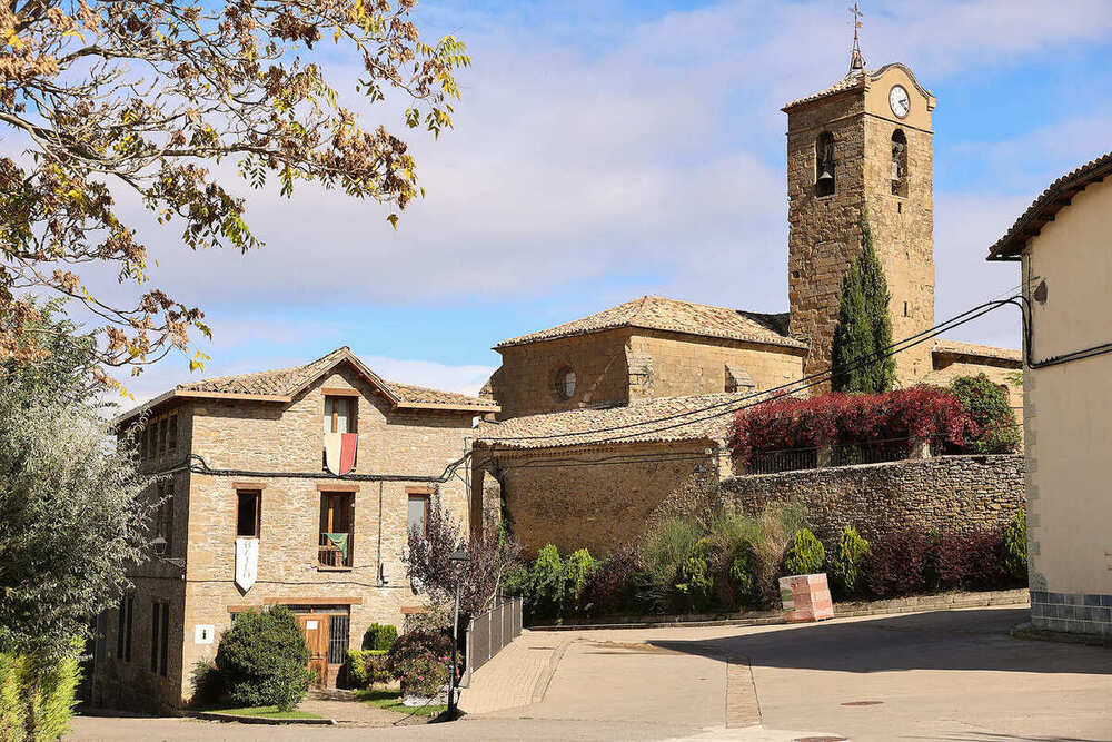 Calle de Bailo, tras un muro se encuentra la iglesia con el campanario