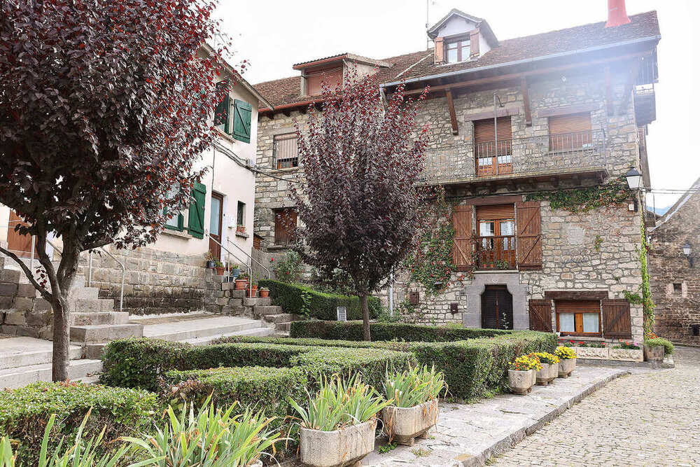 Plaza con setos y casas de piedra