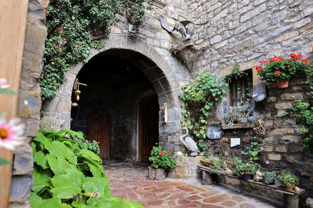 Puerta con arco de piedra decorada con flores
